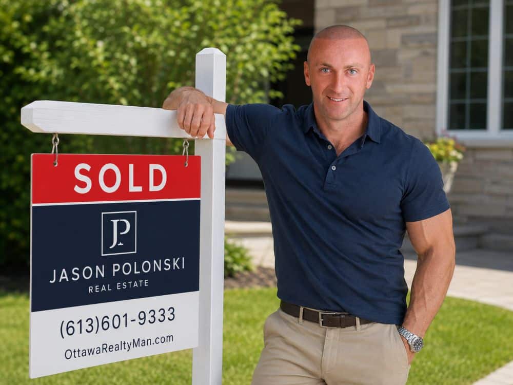 Jason Polonski- Realtor in Kanata, Ottawa is standing next to his sold sign, smiling